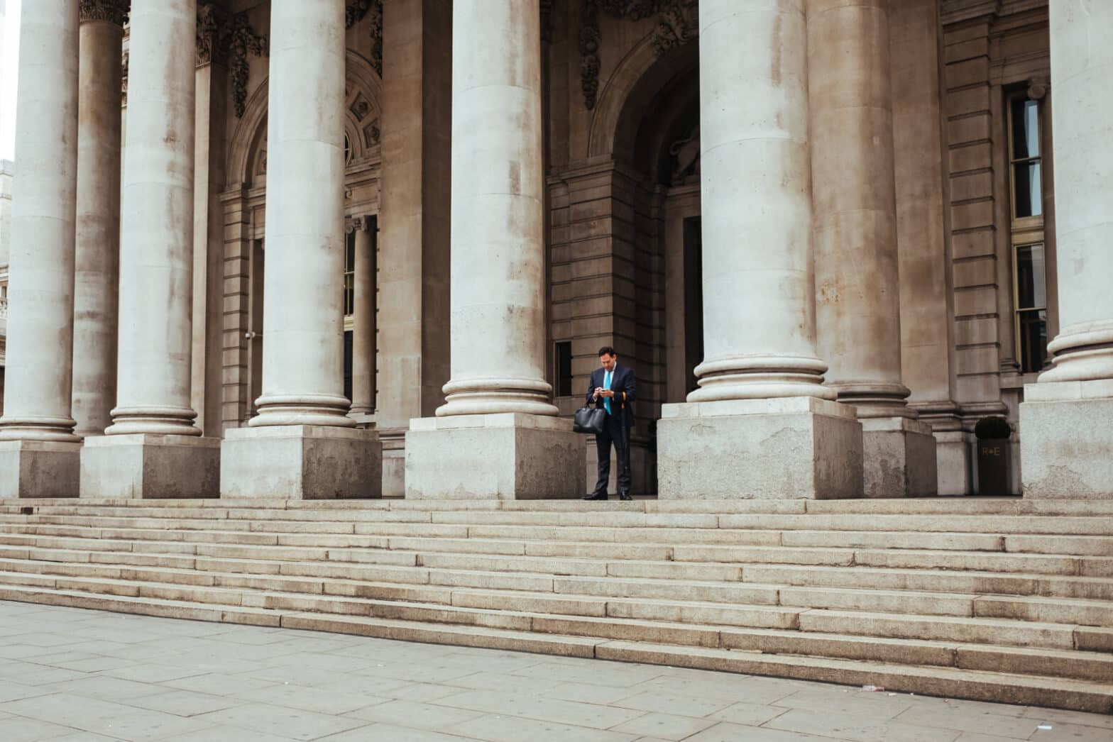 business man standing among architectural columns
