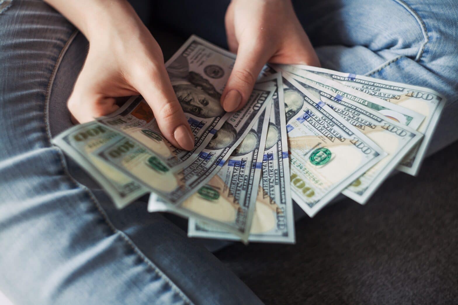 close up hands holding hundred dollar bills