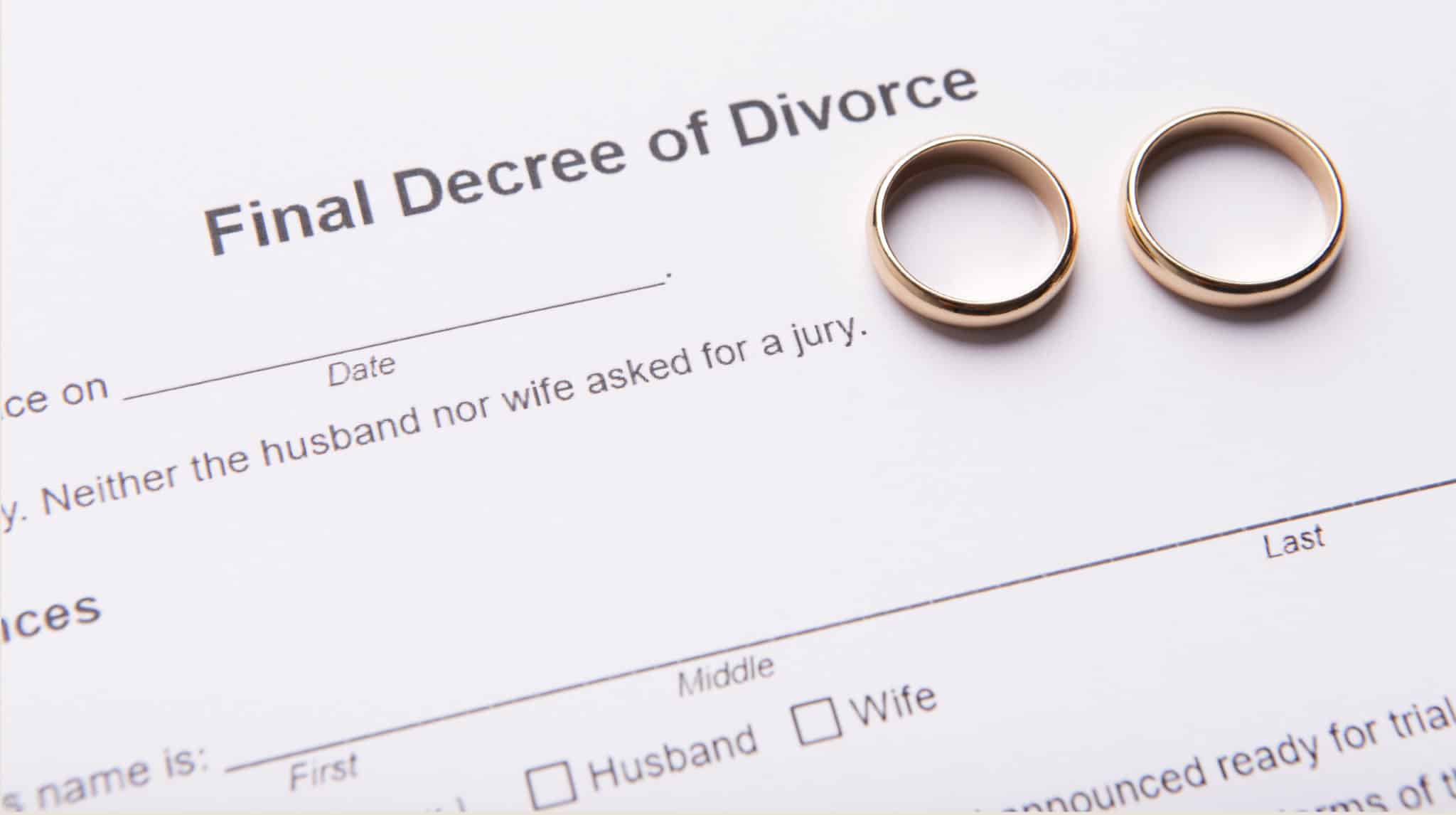Two golden wedding rings on final divorce decree document