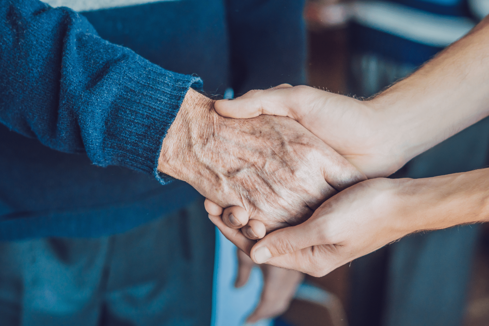 older and younger holding hands